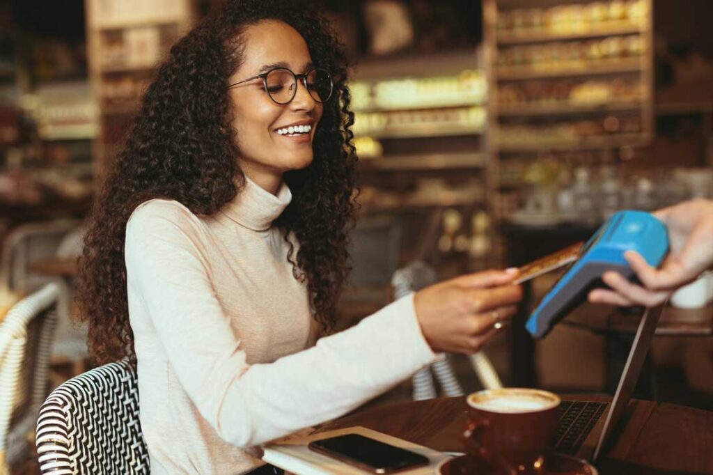 Woman making cashless payment at a cafe