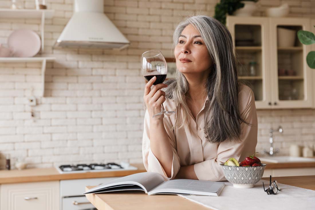 older woman drinking wine in damp january