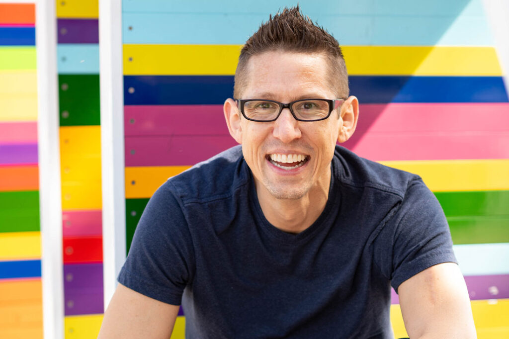 Headshot of Hal Elrod with colorful backdrop