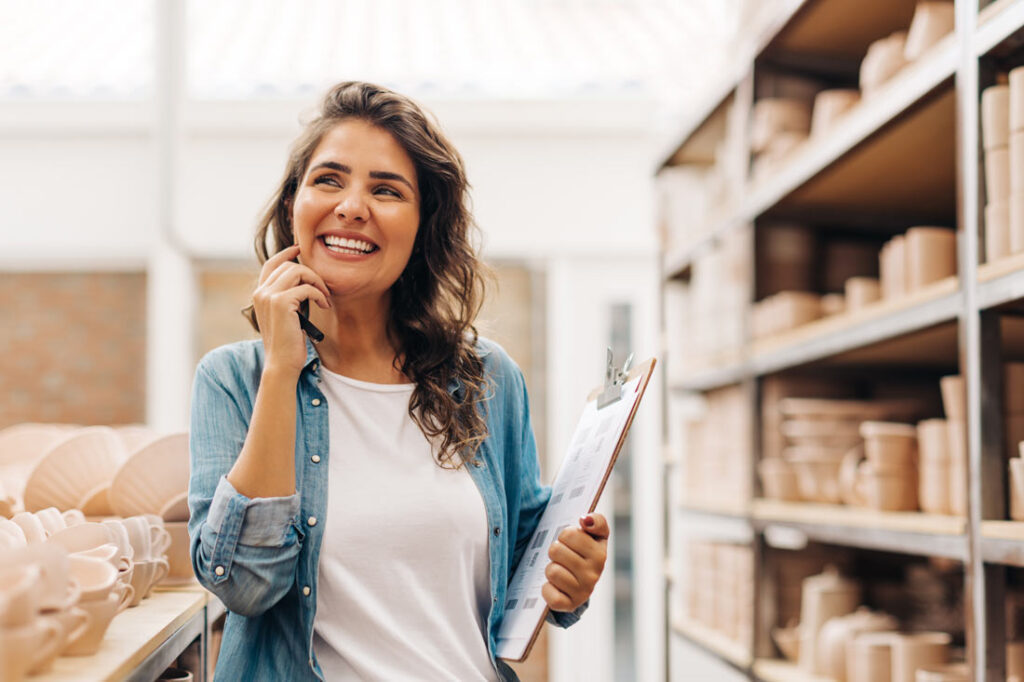 businesswoman smiling in her store of pottery because she's learning the difference between hard skills vs soft skills