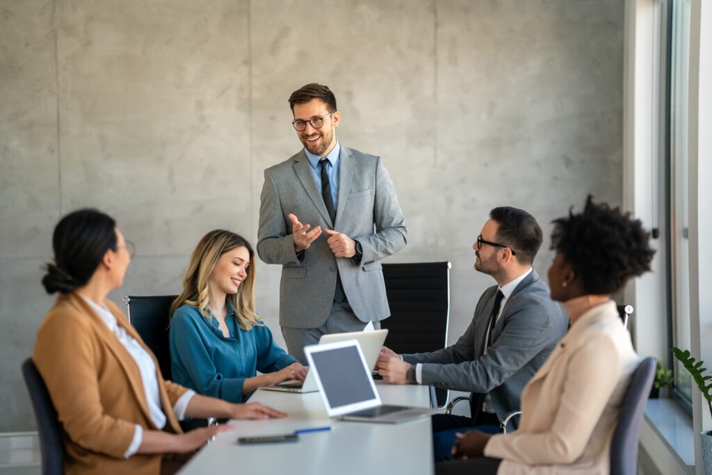 a boss and his staff having a work meeting in a workplace conference room