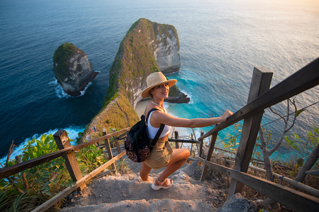 Woman hiking down to tropical beach