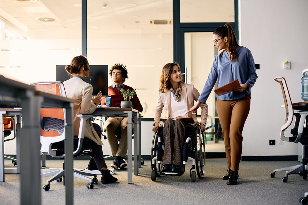 woman talking to female coworker in wheelchair