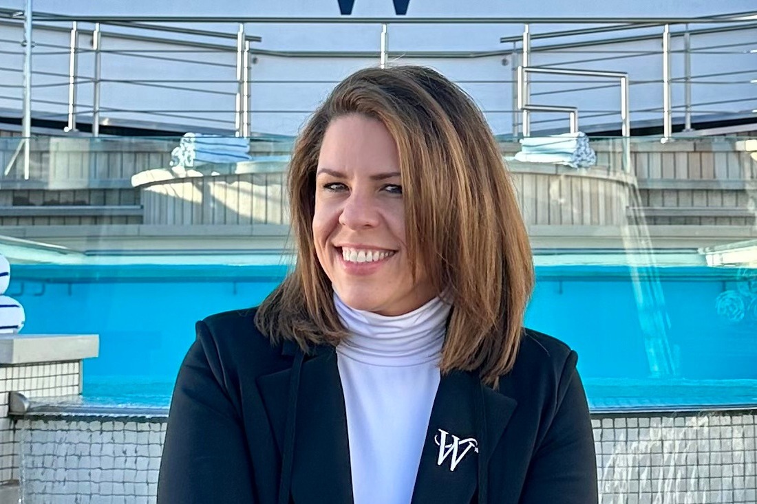 Janet Bava sitting near the pool deck of a cruise ship taking a picture