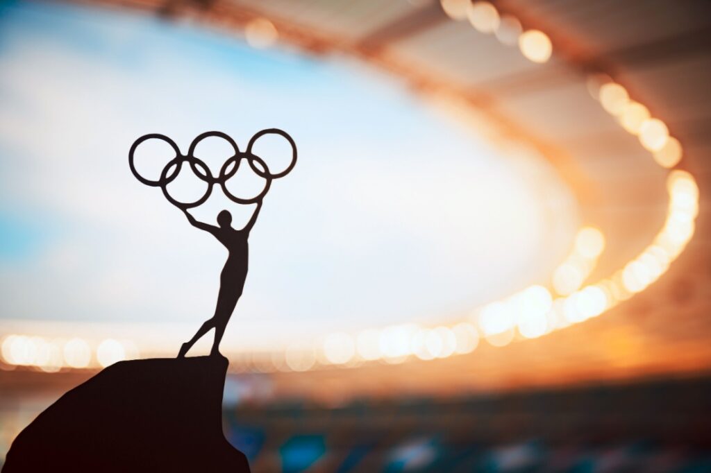 An Olympic statue depicting a man holding up the Olympics symbol.