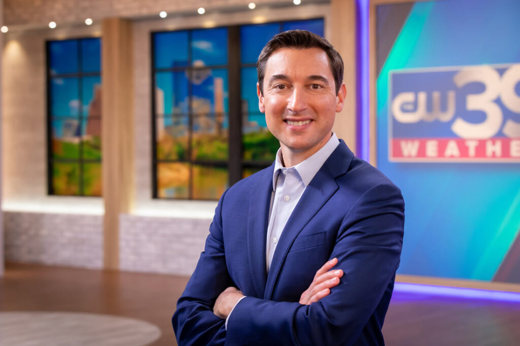 Adam Krueger wearing a suit with arms crossed in the new studio